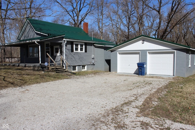 view of front of property featuring a garage, an outbuilding, and covered porch