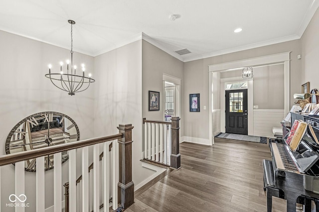 entrance foyer with an inviting chandelier, dark hardwood / wood-style floors, and crown molding