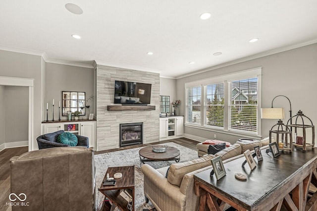 living room featuring a tile fireplace, crown molding, and dark hardwood / wood-style flooring