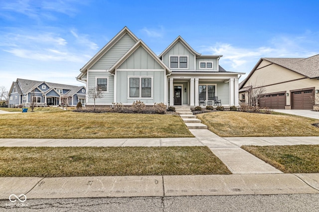 view of front of house featuring a garage, a front lawn, and covered porch