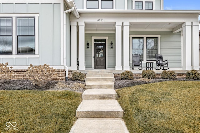 entrance to property featuring a yard and a porch