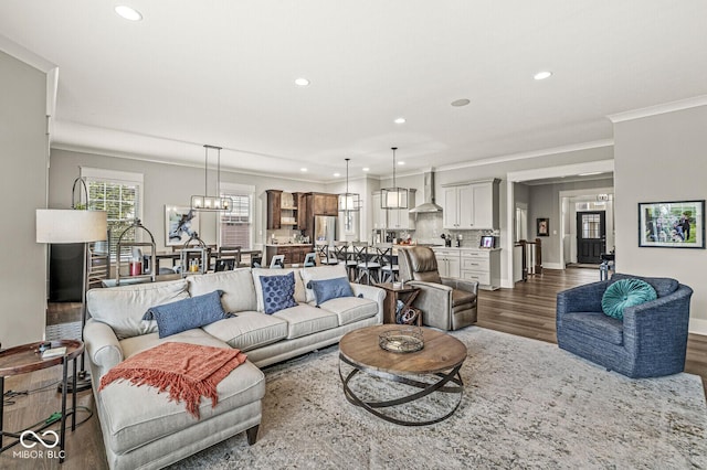 living room featuring ornamental molding, dark wood-type flooring, and a chandelier