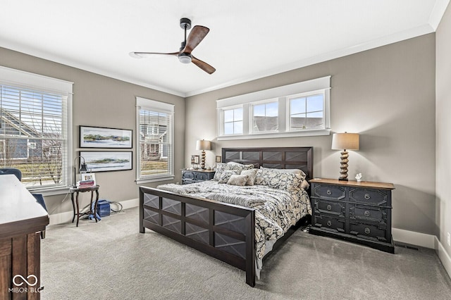 carpeted bedroom with ceiling fan, ornamental molding, and multiple windows