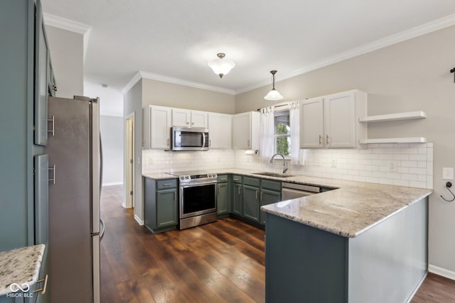 kitchen with a peninsula, dark wood-type flooring, appliances with stainless steel finishes, and a sink