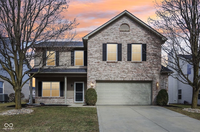 traditional-style home with central air condition unit, driveway, a yard, an attached garage, and brick siding