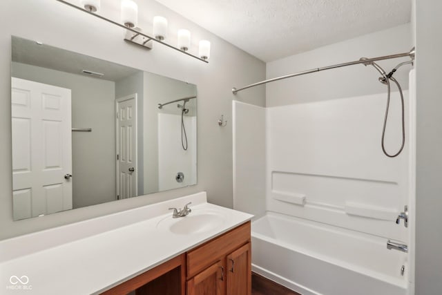 bathroom featuring tub / shower combination, visible vents, a textured ceiling, and vanity