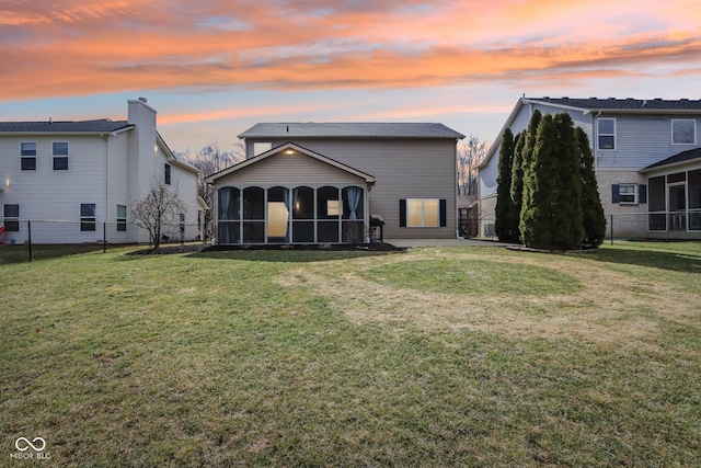 back of house with a yard, fence, and a sunroom