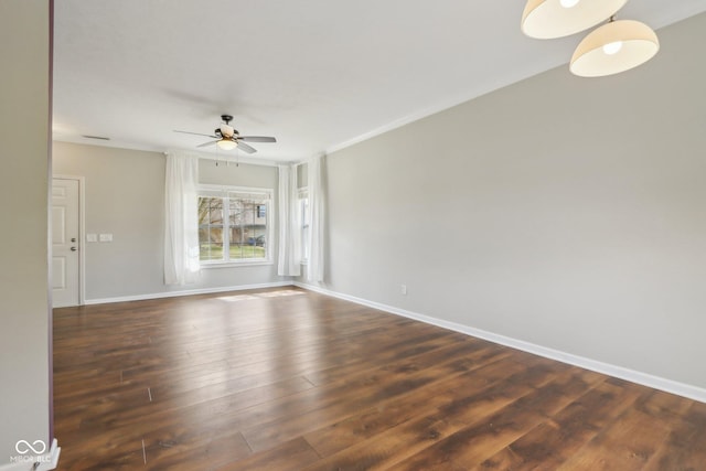 unfurnished room featuring ceiling fan, crown molding, dark wood-type flooring, and baseboards