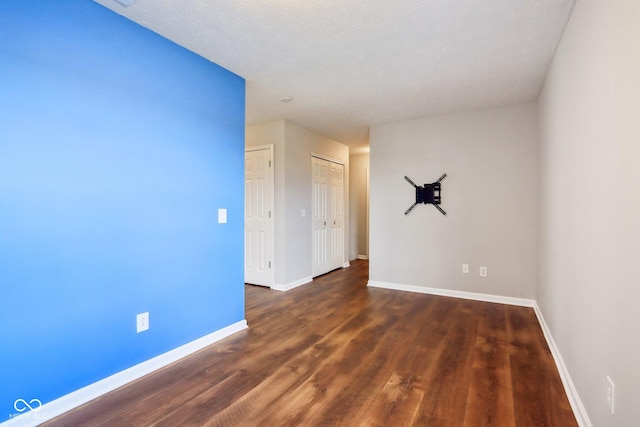 spare room featuring wood finished floors and baseboards