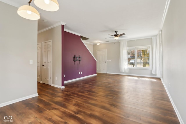 unfurnished living room with a ceiling fan, crown molding, wood finished floors, and baseboards