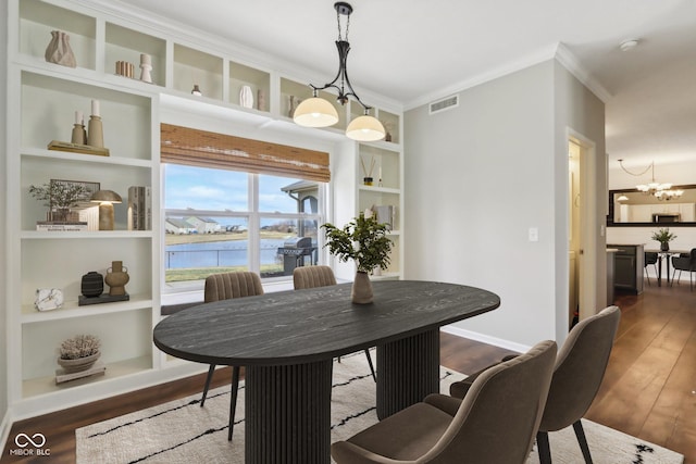 dining space with an inviting chandelier, built in features, visible vents, and dark wood-style flooring