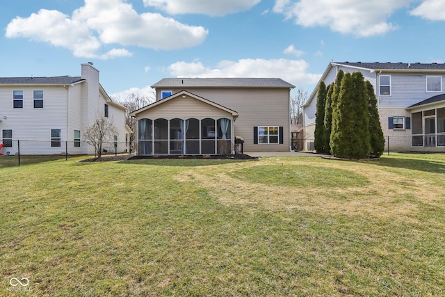 rear view of property with fence, a yard, and a sunroom