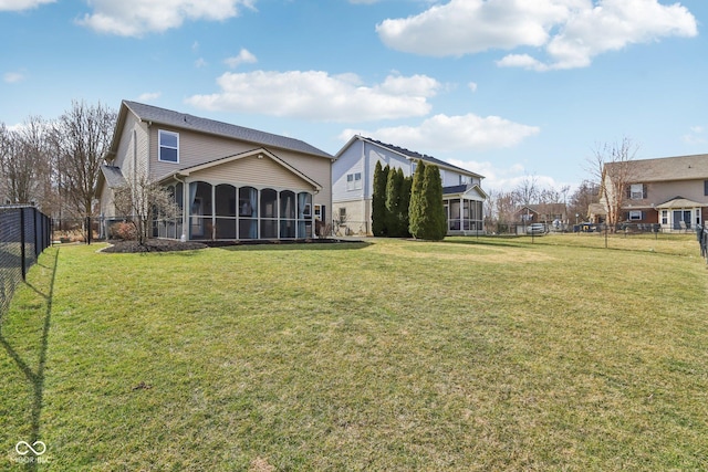 rear view of property with a lawn, a fenced backyard, and a sunroom