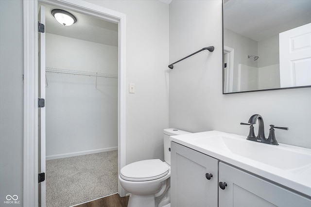 bathroom with vanity, toilet, and a shower