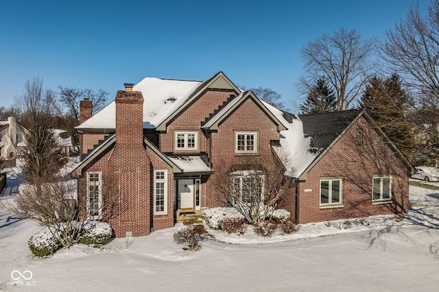 view of front of property with brick siding and a chimney