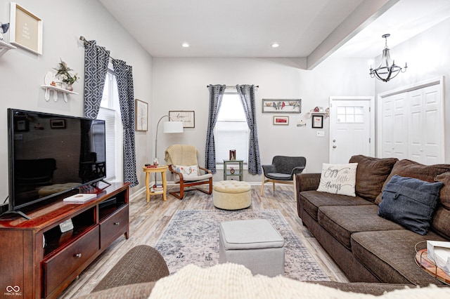 living room featuring an inviting chandelier and light hardwood / wood-style flooring
