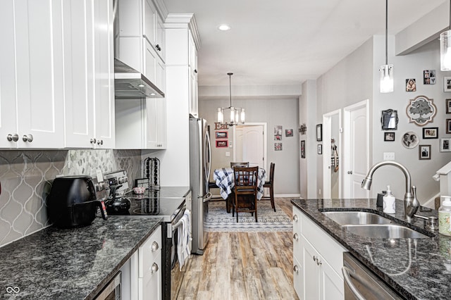kitchen with stainless steel appliances, sink, pendant lighting, and white cabinets