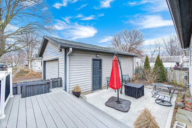 wooden terrace featuring an outbuilding and a garage
