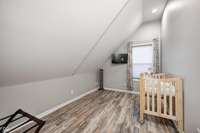 additional living space with wood-type flooring and vaulted ceiling