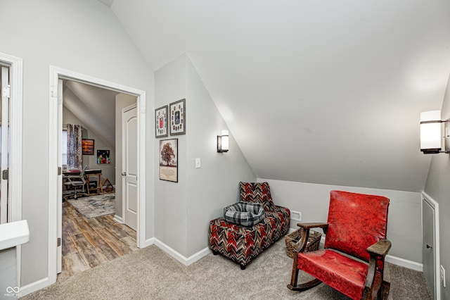living area with carpet floors and vaulted ceiling