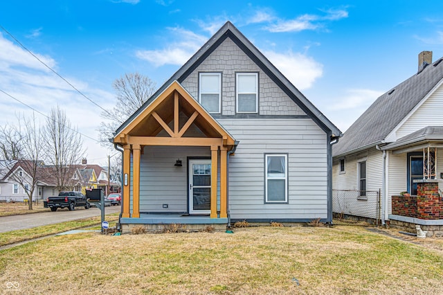 bungalow-style home featuring a front yard and covered porch