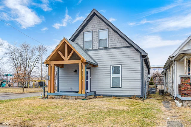 view of front of property with a porch, central AC unit, and a front lawn