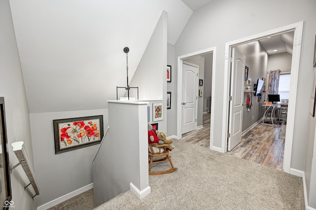 hallway featuring vaulted ceiling and carpet
