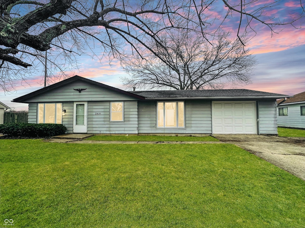 single story home with a garage and a lawn