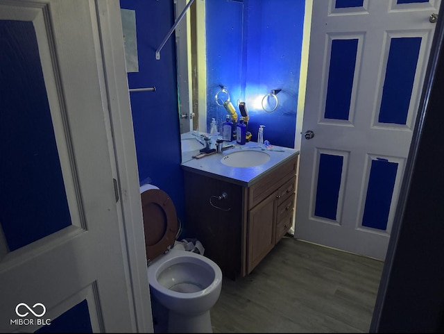 bathroom with vanity, wood-type flooring, and toilet