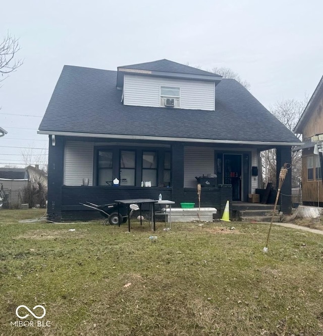 rear view of property featuring a porch and a lawn