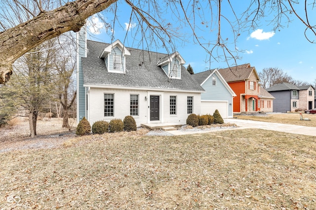 new england style home featuring a garage and a front yard