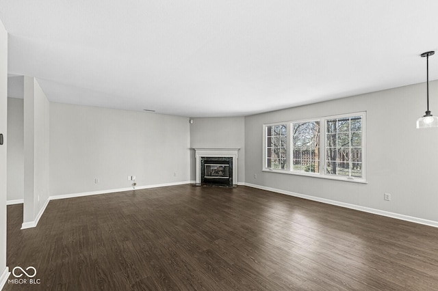 unfurnished living room featuring dark hardwood / wood-style flooring and a high end fireplace