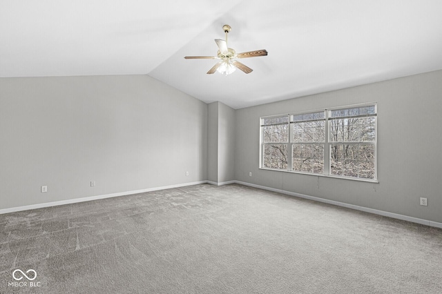 carpeted spare room with ceiling fan and vaulted ceiling