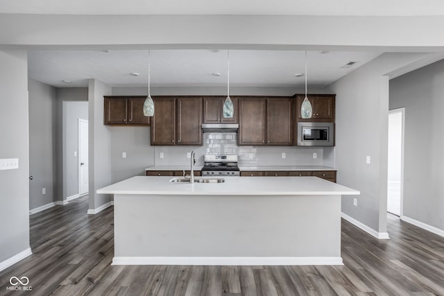 kitchen featuring stainless steel appliances, pendant lighting, sink, and a center island with sink