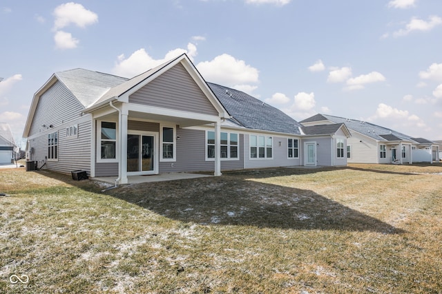 rear view of property featuring central AC unit, a yard, and a patio