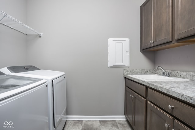 clothes washing area featuring separate washer and dryer, sink, and cabinets