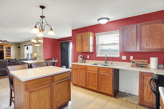 kitchen featuring pendant lighting, sink, light tile patterned floors, a center island, and black range with electric cooktop