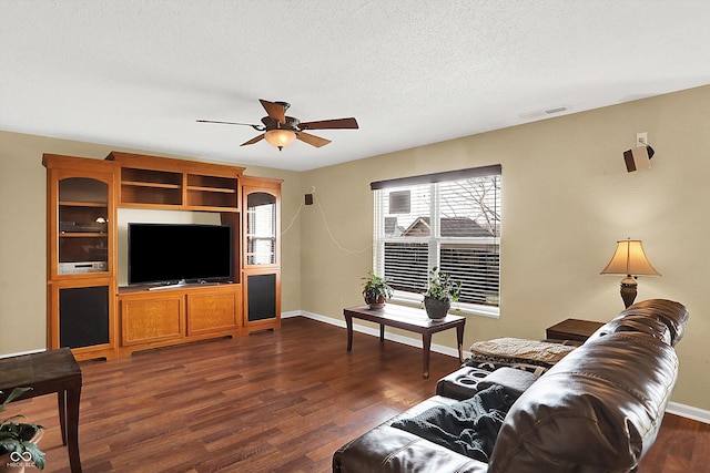 living room with ceiling fan, dark hardwood / wood-style floors, and a textured ceiling