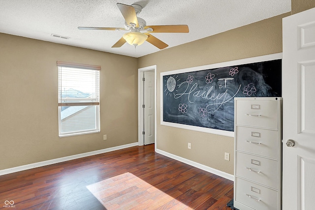 unfurnished bedroom with dark hardwood / wood-style flooring, ceiling fan, and a textured ceiling