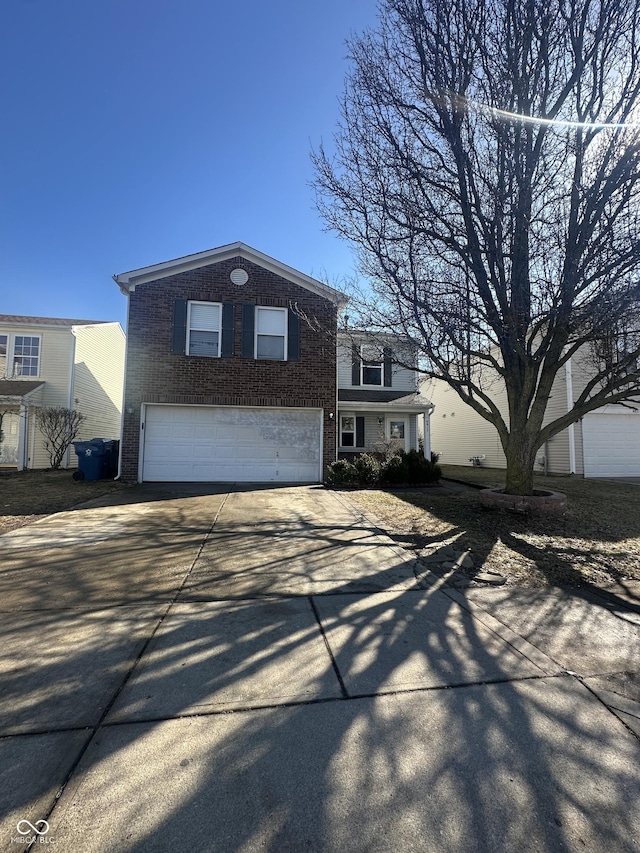 traditional-style house with an attached garage, driveway, and brick siding