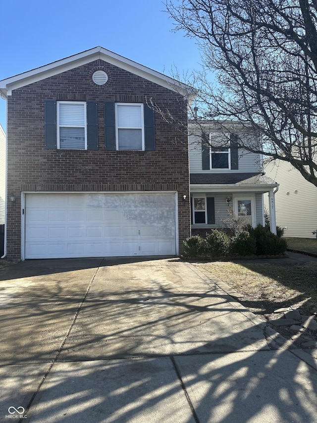 traditional-style home featuring a garage, concrete driveway, and brick siding