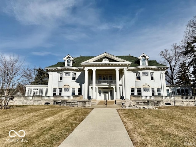 view of front of property featuring a balcony and a front yard