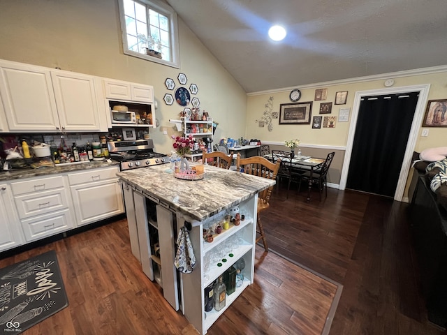 kitchen with stainless steel range oven, a center island, dark hardwood / wood-style floors, stone counters, and white cabinets