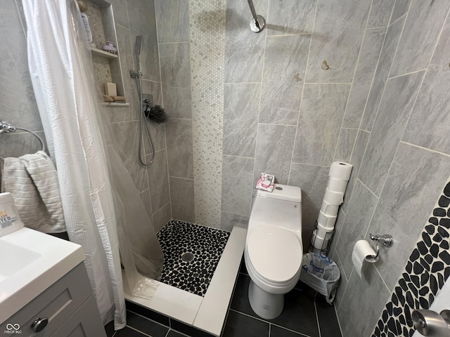 bathroom featuring curtained shower, tile walls, tile patterned flooring, vanity, and toilet