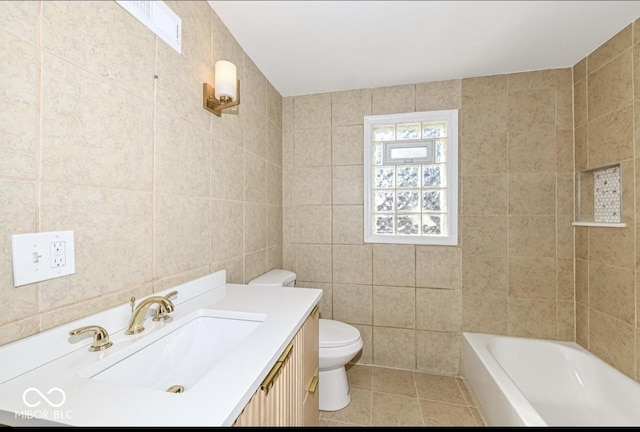 bathroom featuring toilet, a bathing tub, tile patterned floors, vanity, and tile walls