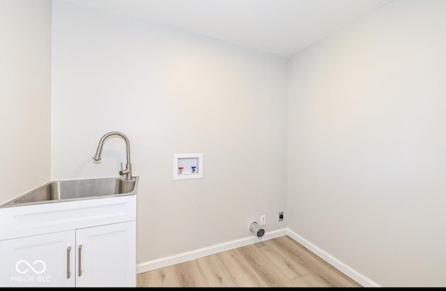 laundry room featuring light wood finished floors, hookup for a washing machine, hookup for an electric dryer, a sink, and baseboards