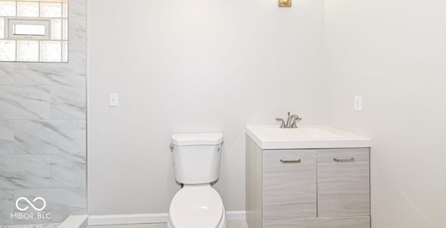 bathroom with vanity, toilet, and baseboards