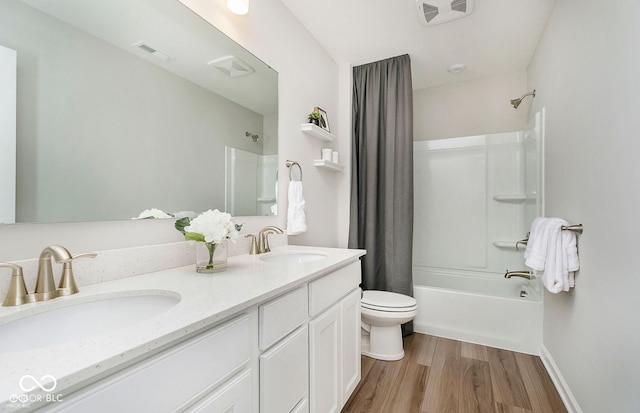 full bathroom with hardwood / wood-style flooring, vanity, toilet, and tub / shower combination