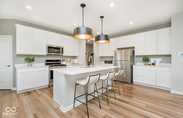 kitchen with stainless steel appliances, hanging light fixtures, light countertops, and white cabinets