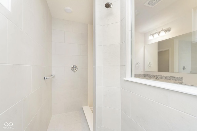 bathroom featuring visible vents and tiled shower